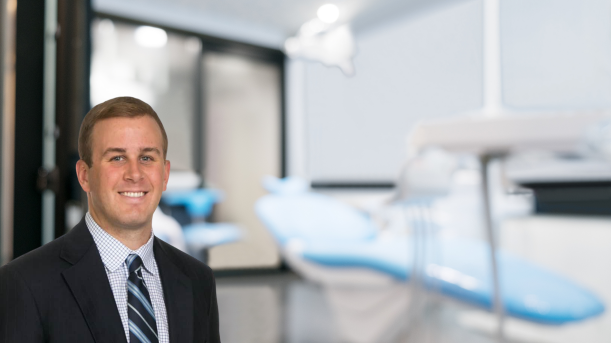 A professional man smiling confidently in a modern dental clinic.